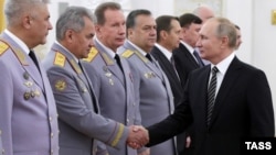 Russia's President Vladimir Putin (right) greets Interior Minister Vladimir Kolokoltsev (left), Russia's Defense Minister Sergei Shoigu (second left), and Viktor Zolotov (third right), head of Russia's Federal National Guard Service, at a ceremony at the Kremlin in 2019.