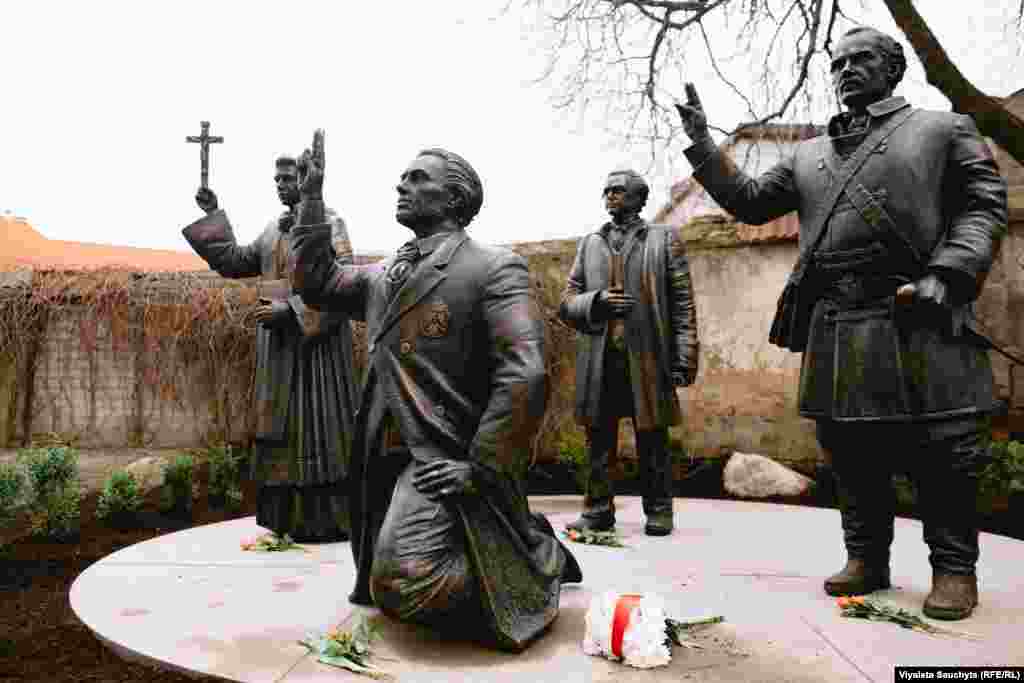 На пярэднім пляне ўкленчаны Каліноўскі, а за ягонай сьпінай — Серакоўскі, абодва з паднятымі ў жэсьце клятвы рукамі: прысягаюць у вернасьці Богу і Радзіме. Воддаль стаіць скульптура Далеўскага