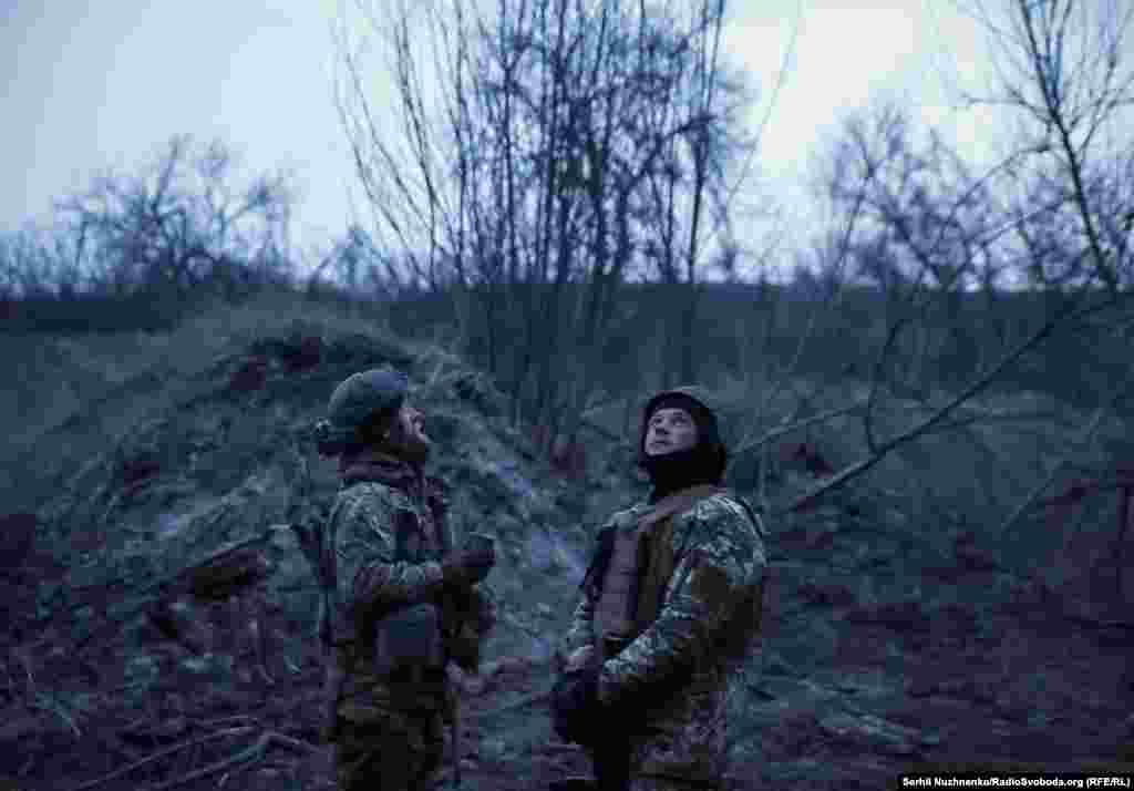 Украинские военные смотрят на небо, отслеживая возможные прилеты российских беспилотников. Бахмут, 6 марта 2024 года