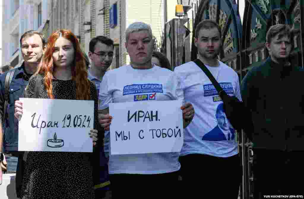 Люди держат плакаты с надписями «Иран — 19.05.2024» (слева) и «Иран, мы с тобой» возле посольства в Москве