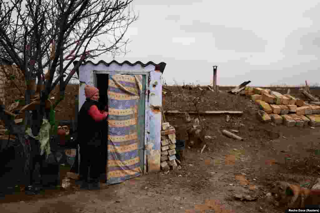 Тетяна біля входу до посіченого осколками від обстрілів льоху, де вони зі Степаном зараз живуть