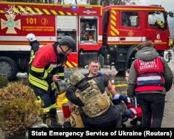 Рятувальники надають допомогу постраждалому колезі, який постраждав внаслідок застосування російською армією техніки подвійного удару. Одеса, Україна, 15 березня 2024 року