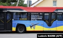 Натівський автобус з написами «Озброюйте Україну» та «Поки ви чекаєте на цей автобус, Україна чекає на F-16», припаркований біля місця проведення саміту НАТО у столиці Литви. Вільнюсі 11 липня 2023 року