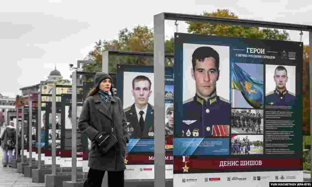 Россиянка стоит у выставки фото солдат, воевавших во время российского неспровоцированного вторжения в Украину, под названием «Герои с вечным русским сердцем» в Москве, 17 октября.