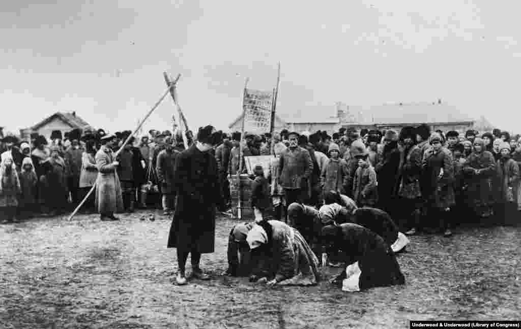 Голодные женщины становятся на колени перед сотрудником гуманитарной миссии США, 1922 год. Большевики побеждают после 5 лет яростных сражений 