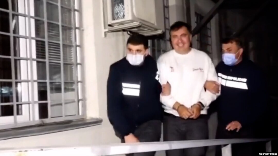 A smiling Mikheil Saakashvili is shown in handcuffs in a video released by the Georgian Interior Ministry.