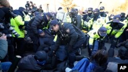 Офіцери поліції відтягують прихильників президента Південної Кореї Юн Сук Йоля, оскільки йому загрожує потенційний арешт після того, як суд у вівторок ухвалив ордер на його арешт, біля президентської резиденції в Сеулі, Південна Корея, четвер, 2 січня 2025 року