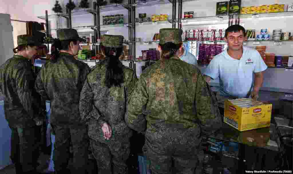 Un grup de femei din armata rusă, așteptând la coadă la un magazin de pe teritoriul bazei Hmeimim, în februarie 2016. Expertul Ben Dubow a spus că Moscova ar putea fi capabilă să-și negocieze o prezență redusă în Siria, „pentru a deține în continuare puncte de tranzit esențiale pentru a-și proiecta forța în Orientul Mijlociu și Africa”.