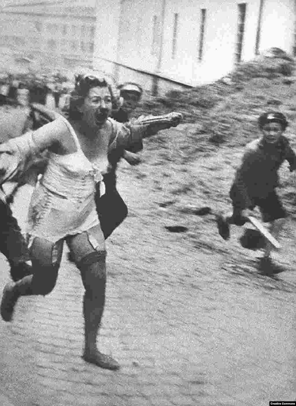 Еврейка убегает от толпы во Львове. Город в межвоенное время был польским, затем оккупирован СССР и в конце – нацистами. Фото сделано в июне или июле 1941 года. При активном поощрении нацистов евреи советской Украины и других оккупированных территорий переживали настоящий ужас. Тысячи из них были замучены и убиты в результате погромов, устроенных в Центральной и Восточной Европе.