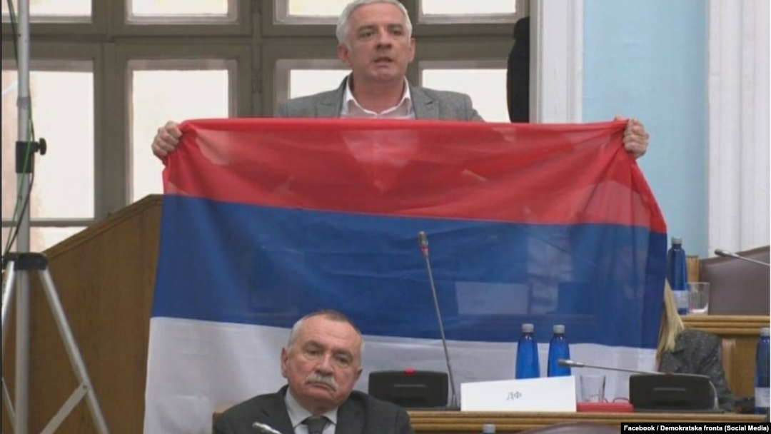 Oopposition Democratic Front deputy Jovan Vucurovic takes out a Serbian tricolor flag during a session of the Montenegrin parliament in Podgorica on March 4.