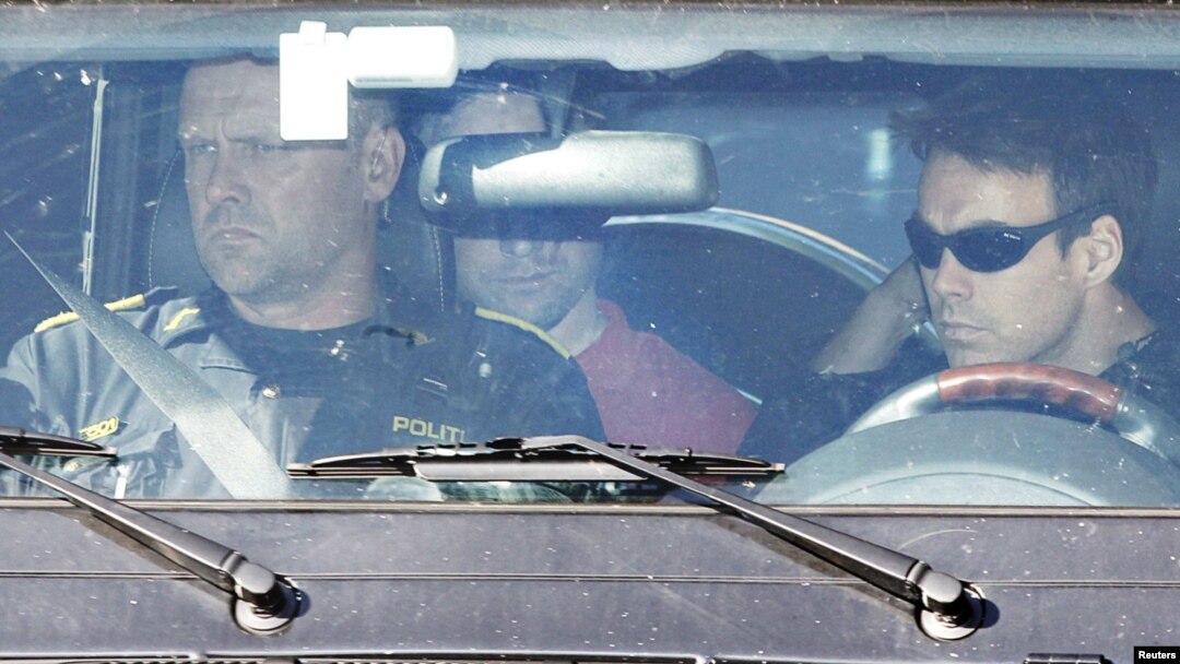 Accused gunman Anders Behring Breivik, partially obscured by a rearview mirror, sits in a police vehicle as he is escorted from Ila prison in Baerum, to be brought to the main police station in Oslo for questioning on July 29