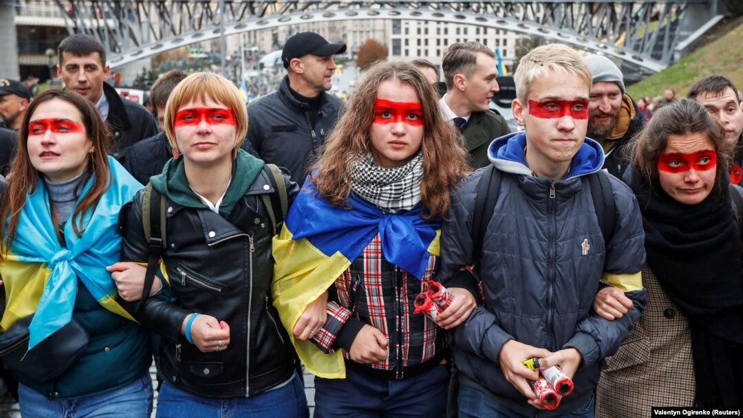 Учасники віча «Зупинимо капітуляцію!» із «червоною лінією» на обличчях під час час здійснення обходу урядового кварталу. Київ, 6 жовтня 2019 року