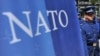 Vojnik Oružanih snaga BiH stoji ispred banera na kojem je zastava NATO-a, Sarajevo, fotoarhiv