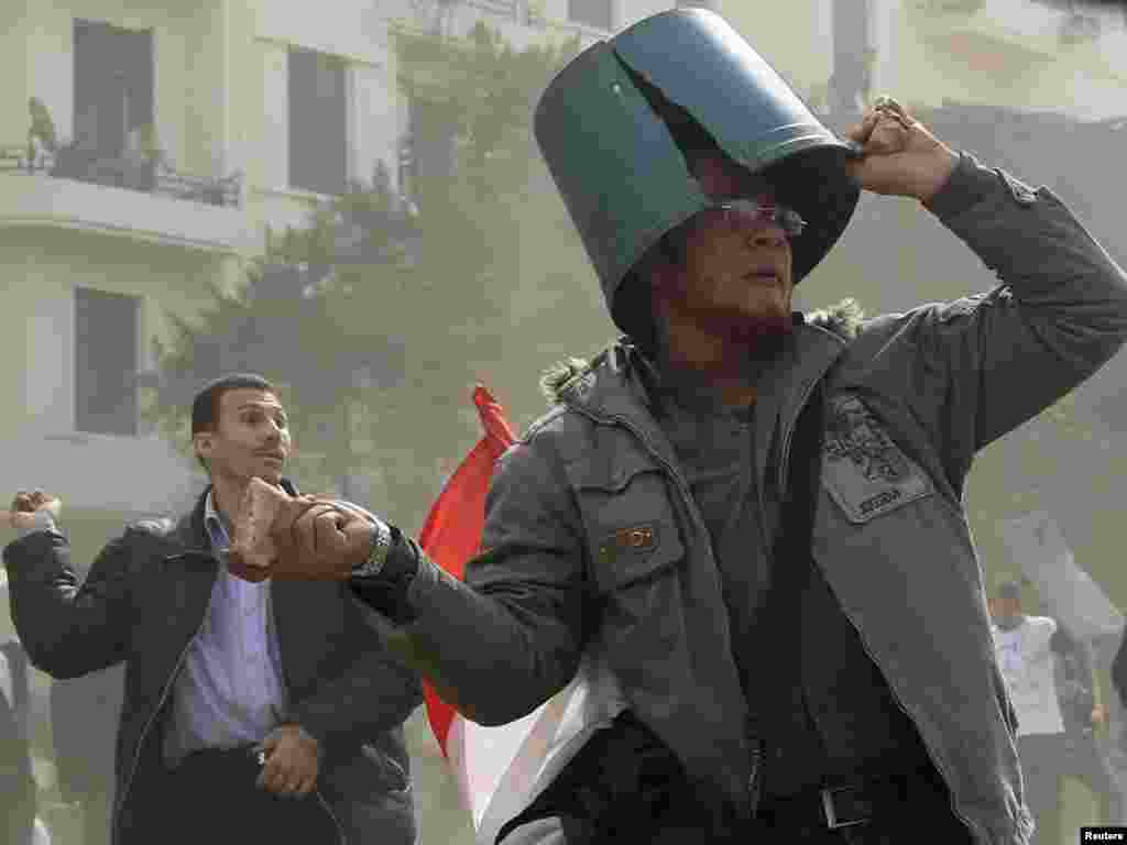 تظاهرکنندگان در حال پرتاب سنگ به سمت طرفداران حسنی مبارک، در میدان تحریر قاهره