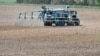 A farmer spreads fertilizer before sowing corn in Brulon, western France. (file photo)