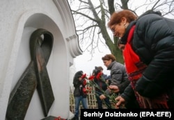 U.S. Ambassador to Ukraine Marie Yovanovitch lays flowers at a memorial to people who have died of AIDS in Kyiv in November.