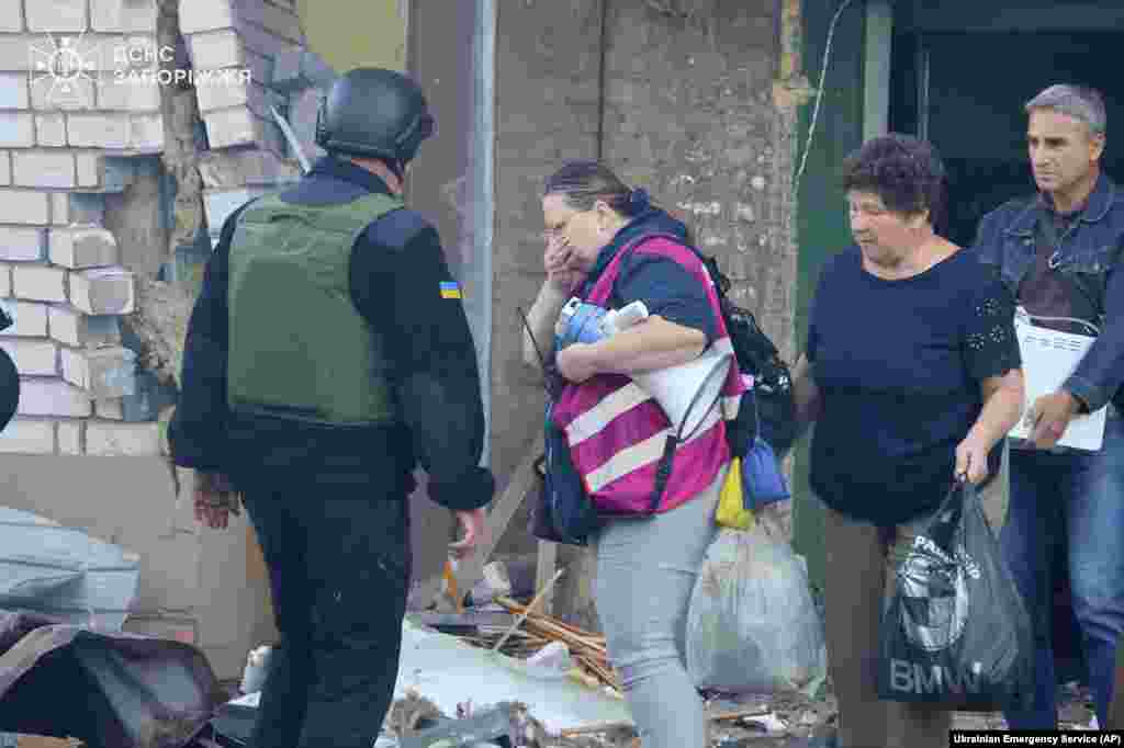 Жыхары пакідаюць пашкоджаны бомбай дом. 