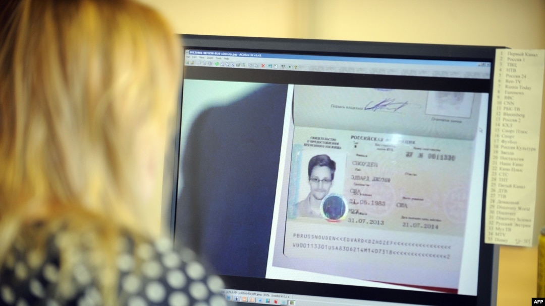 Russia - A woman watches a footage on her computer, showing the lawyer of fugitive US intelligence leaker Edward Snowden showing his client's one year's asylum permit at Sheremetyevo airport in Moscow on August 1, 2013