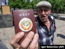 Мешканець Луганська показує український паспорт в обкладинці «під СРСР». Травень 2014 року