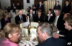 Putin (second left at back), U.S. President George W. Bush (right), and German Chancellor Angela Merkel (front left) attend a reception in Bucharest, Romania, on April 3, 2008, as part of the NATO summit.