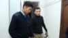 Асет Нуржаубай под конвоем в наручниках перед залом судебного заседания. Алматы, 20 сентября 2018 года. 