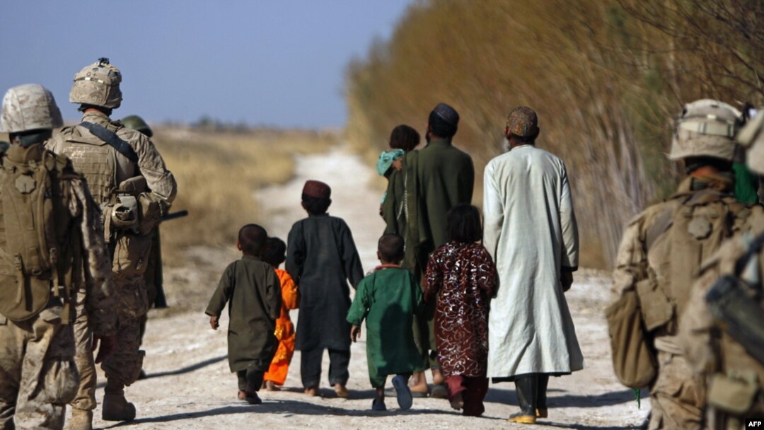 U.S. Marines escort farmers fleeing their land as Marines battle Taliban in Trikh Nawar, near Marjah.