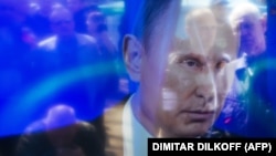 Проросійські активісти відбиваються на екрані телевізора під час виступу президента Росії Володимира Путіна. Луганськ. 17 квітня 2014 року