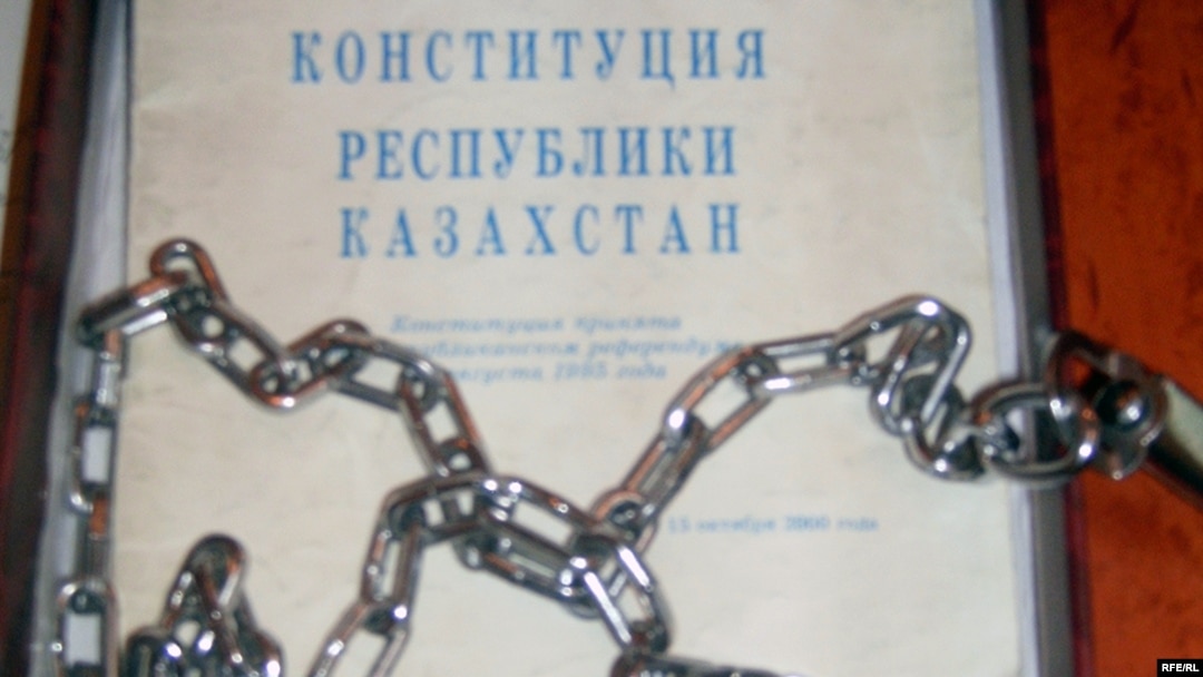 Конституция и цепи, которые активисты партии «Азат» отправили профессору из Актобе Закратдину Байдосову в знак протеста против идеи пожизненного президентства Нурсултана Назарбаева. Талдыкорган, сентябрь 2009 года. (Иллюстративное фото.)
