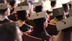 Square academic caps of graduates sitting in the university hall at the presentation of diplomas