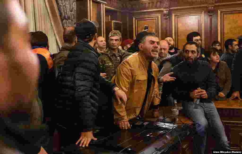 Протестующие в здании правительства. Премьер-министр Никол Пашинян попытался возложить вину за потери в Нагорном Карабахе на предыдущее правительство. Он заявил: "Мы должны готовиться к возмездию. Мы не реагировали должным образом на коррумпированных, олигархических мерзавцев, которые грабили нашу страну, крали у солдат еду, крали у них оружие".