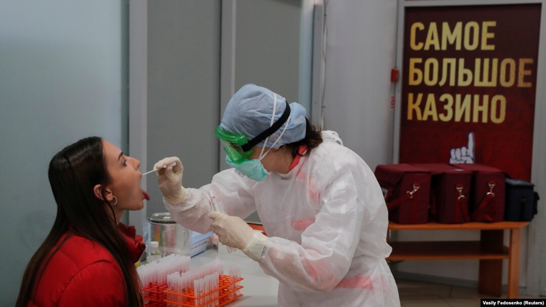 O asistentă efectuează un test pentru depistarea infecției cu coronavirus