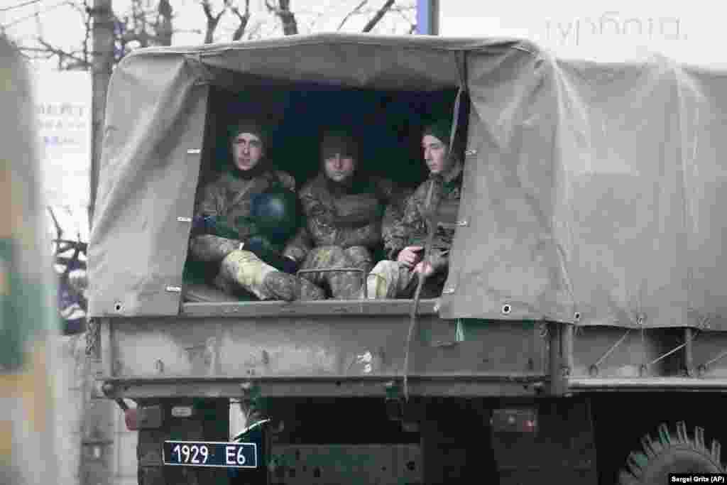 Сарбозони украинӣ дар як худрави низомӣ дар Мариупол.