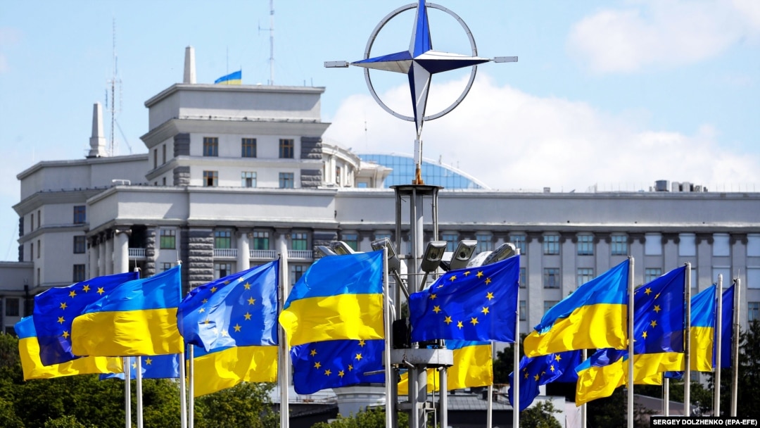 Drapelele Ucrainei și ale UE sub logo-ul NATO, în Piața Europeană din centrul Kievului (imagine de arhivă).