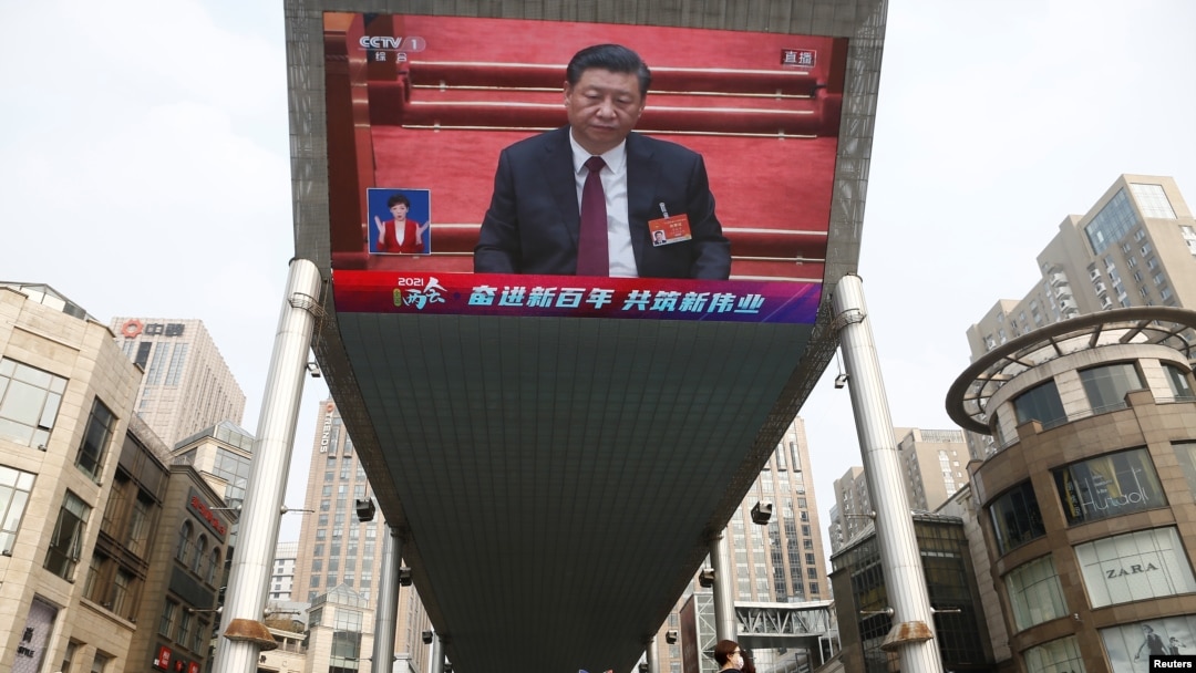 A giant outdoor screen shows Chinese President Xi Jinping attending the closing session of the National People's Congress in Beijing on March 11.