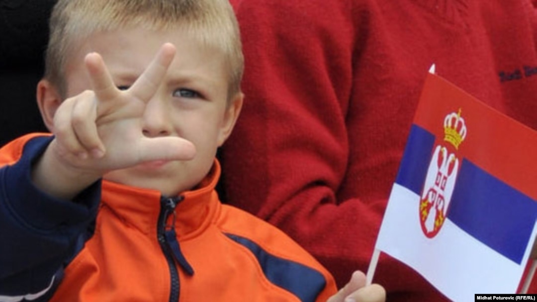 A child shows the traditional Serb three-finger salute in Pale, in Bosnia's Republika Srpska, on September 8. He's waving the Serbian flag.