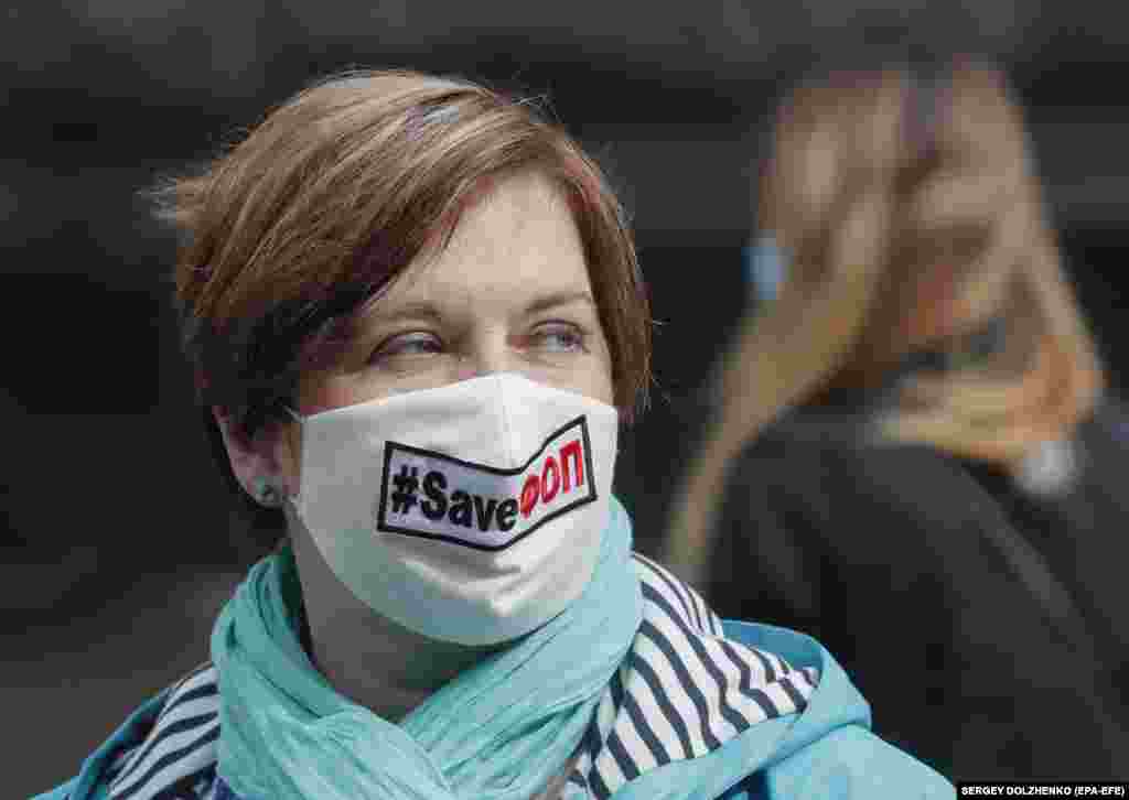 Участница акции протеста в Киеве носит маску с надписью «Спасите малый бизнес»